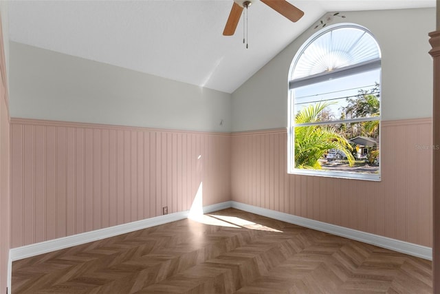 unfurnished room with vaulted ceiling, dark parquet floors, and ceiling fan