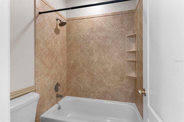 bathroom featuring tiled shower / bath and toilet