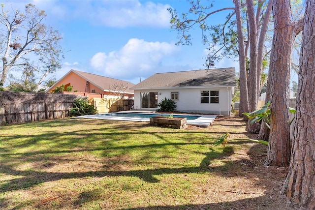 back of house with a fenced in pool, a yard, and a patio