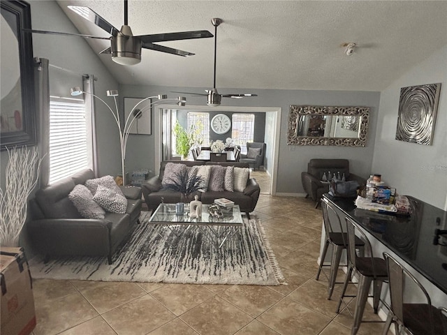 tiled living room featuring vaulted ceiling, a textured ceiling, and ceiling fan