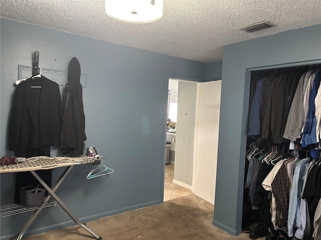 walk in closet with light carpet