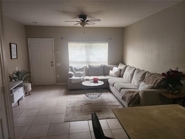 living room with light tile patterned floors, ceiling fan, and a textured ceiling