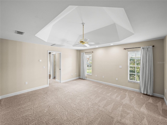 empty room with ceiling fan, light colored carpet, a healthy amount of sunlight, and lofted ceiling