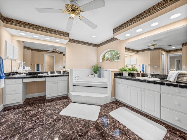 bathroom featuring vanity, a relaxing tiled tub, and ceiling fan