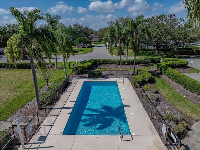 view of swimming pool with a yard