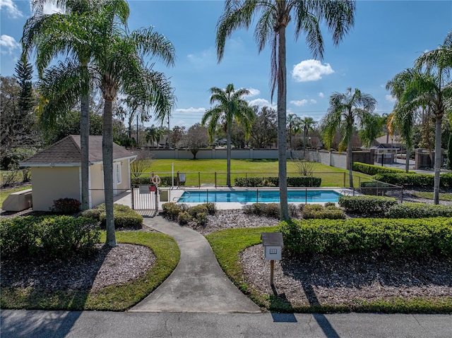 view of home's community featuring a pool and a yard