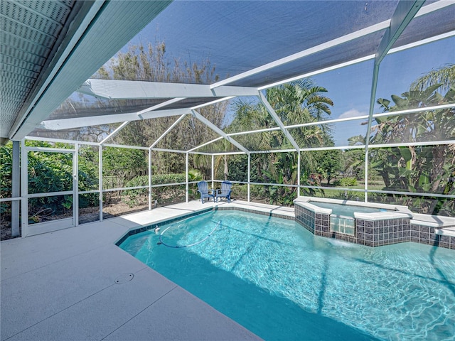 view of pool with a lanai, a patio area, and an in ground hot tub