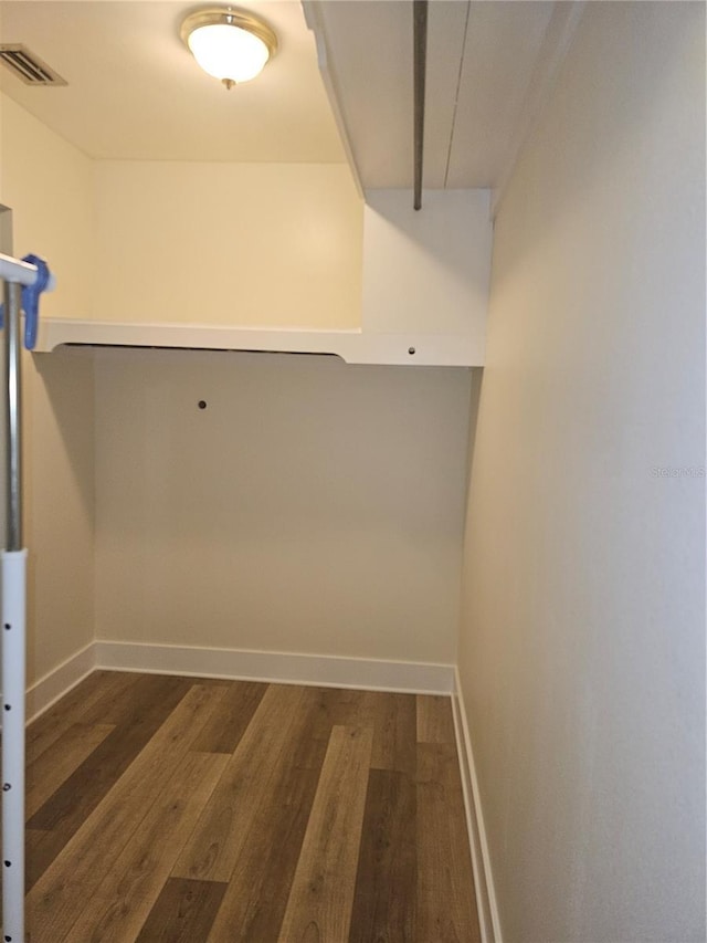 spacious closet featuring dark wood-type flooring and visible vents