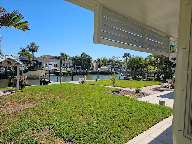 view of yard with a boat dock, a water view, and boat lift