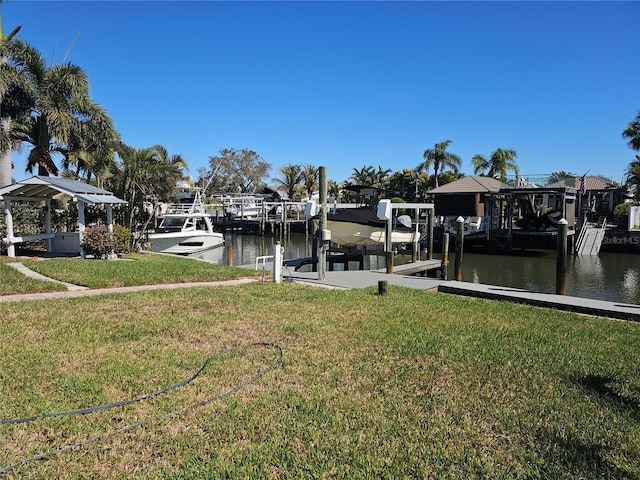 dock area with a water view, boat lift, and a lawn