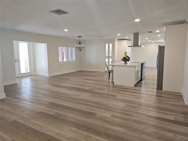 living room with recessed lighting, visible vents, crown molding, and wood finished floors