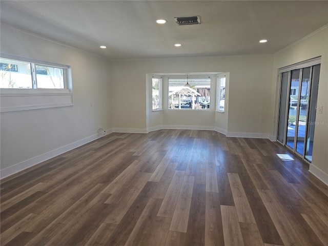 unfurnished room featuring baseboards, dark wood-type flooring, and a wealth of natural light