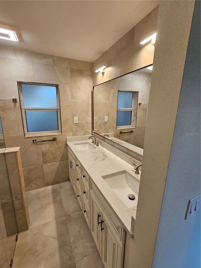 full bath featuring double vanity, a sink, and tile walls