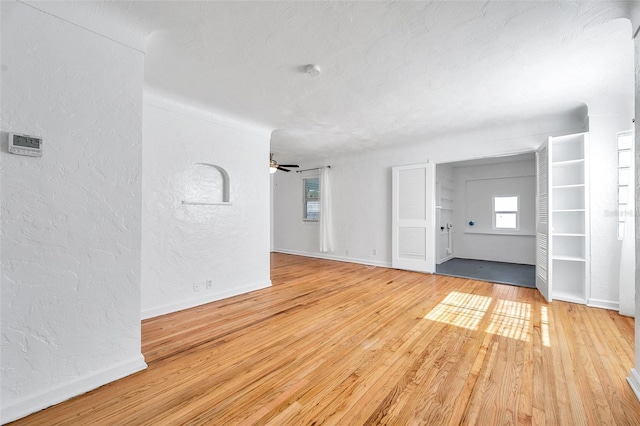 spare room featuring ceiling fan, light hardwood / wood-style flooring, and a textured ceiling