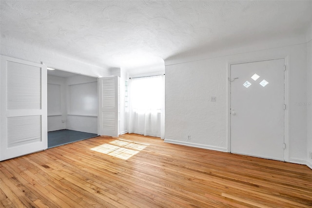 foyer entrance featuring a textured ceiling and light hardwood / wood-style flooring