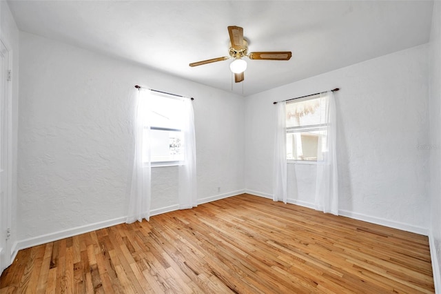 empty room with ceiling fan and light hardwood / wood-style floors