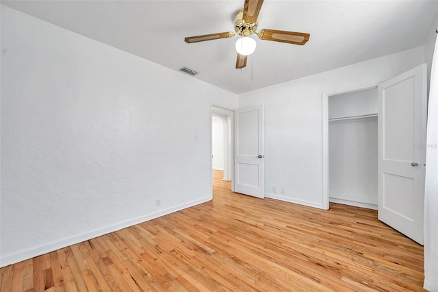 unfurnished bedroom featuring ceiling fan, light hardwood / wood-style floors, and a closet