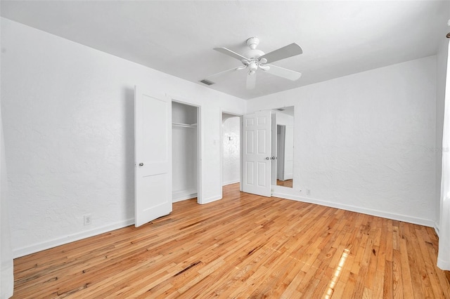 unfurnished bedroom featuring ceiling fan, light wood-type flooring, and a closet