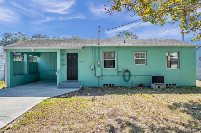 view of front facade with central AC, a front lawn, and a carport