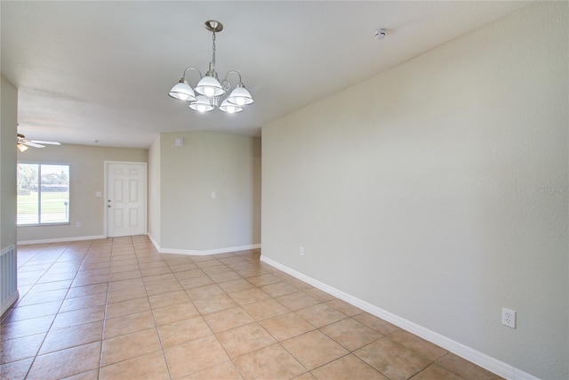 empty room with ceiling fan with notable chandelier, baseboards, and light tile patterned floors