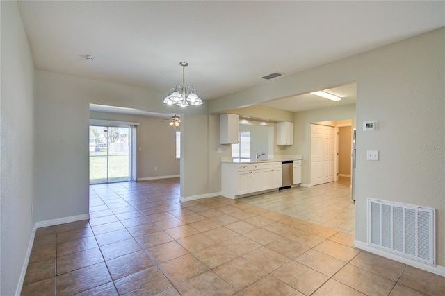 interior space featuring baseboards, stainless steel dishwasher, visible vents, and white cabinets