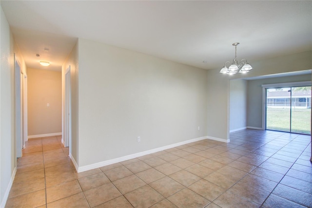 unfurnished room with light tile patterned floors, baseboards, and a chandelier