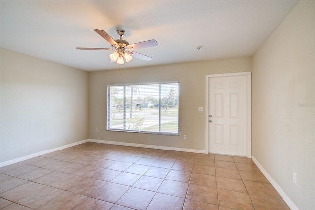 unfurnished room with light tile patterned floors, a ceiling fan, and baseboards