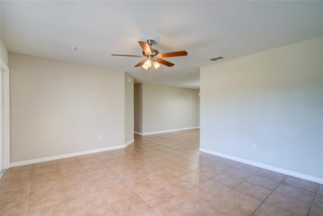 spare room with a ceiling fan, visible vents, baseboards, and light tile patterned flooring