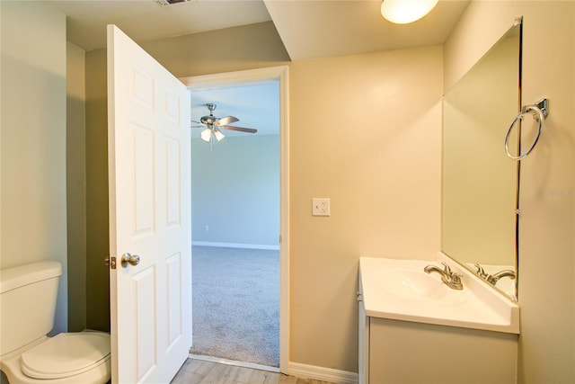 bathroom with toilet, baseboards, visible vents, and vanity