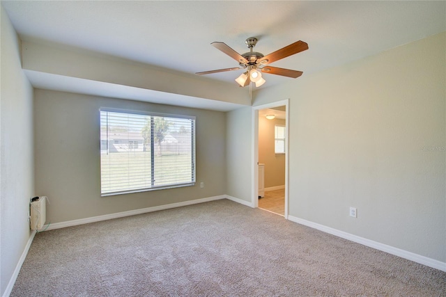 unfurnished room with a healthy amount of sunlight, ceiling fan, baseboards, and carpet flooring