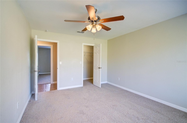 unfurnished bedroom with a closet, visible vents, light carpet, ceiling fan, and baseboards