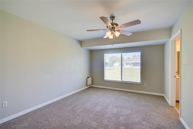 carpeted spare room with ceiling fan and baseboards