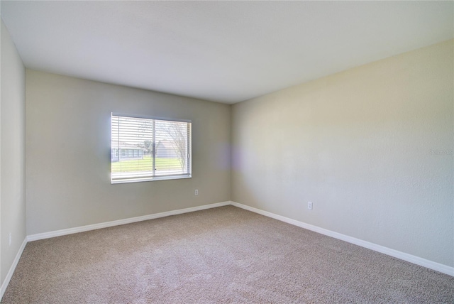 empty room with carpet and baseboards