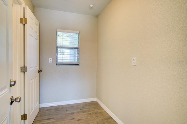 unfurnished room with light wood-type flooring and baseboards