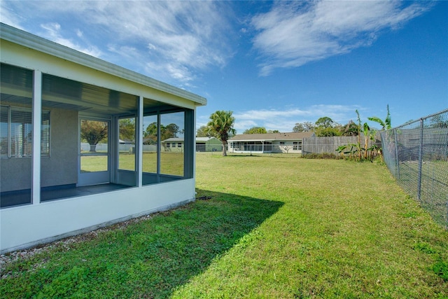 view of yard featuring a fenced backyard and a sunroom