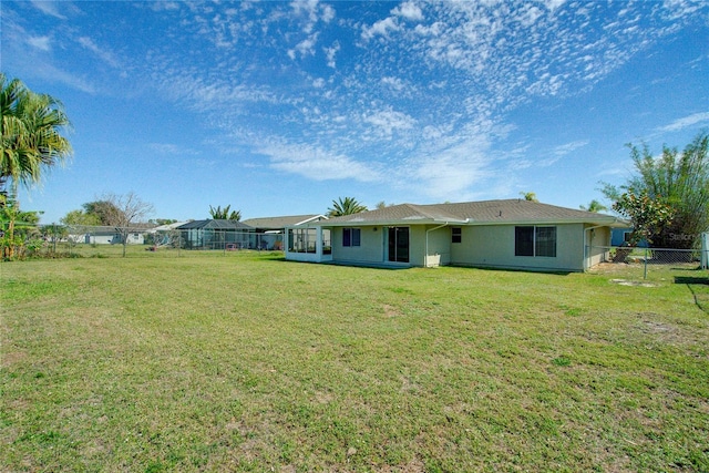 back of property with fence and a yard