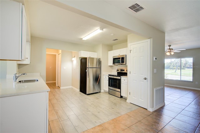 kitchen with stainless steel appliances, white cabinets, visible vents, and a sink