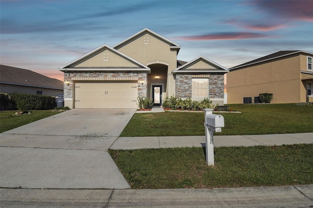 ranch-style house featuring a garage and a yard