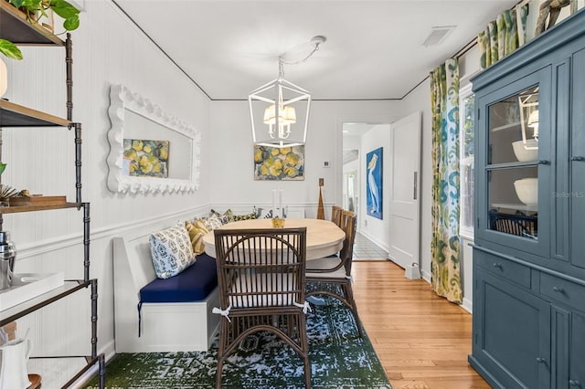 dining area featuring breakfast area, light hardwood / wood-style flooring, and an inviting chandelier