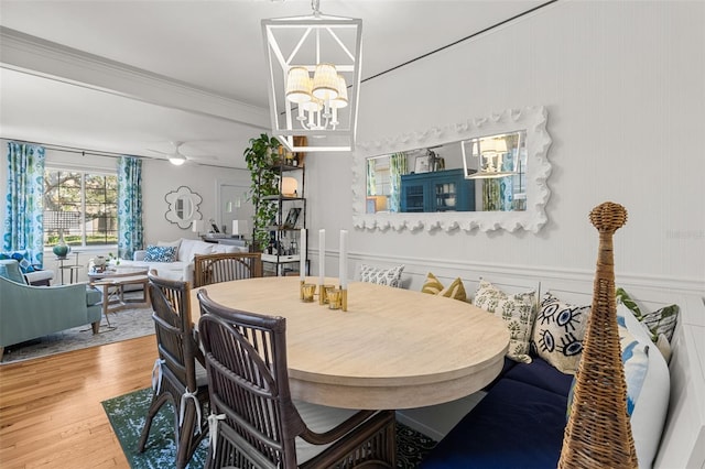 dining room featuring hardwood / wood-style flooring, ceiling fan with notable chandelier, and ornamental molding