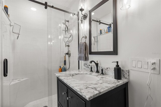 bathroom with a shower with door and vanity