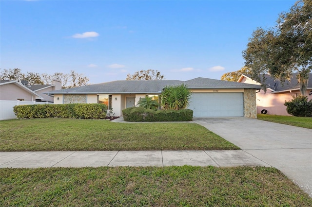 single story home with a garage and a front lawn