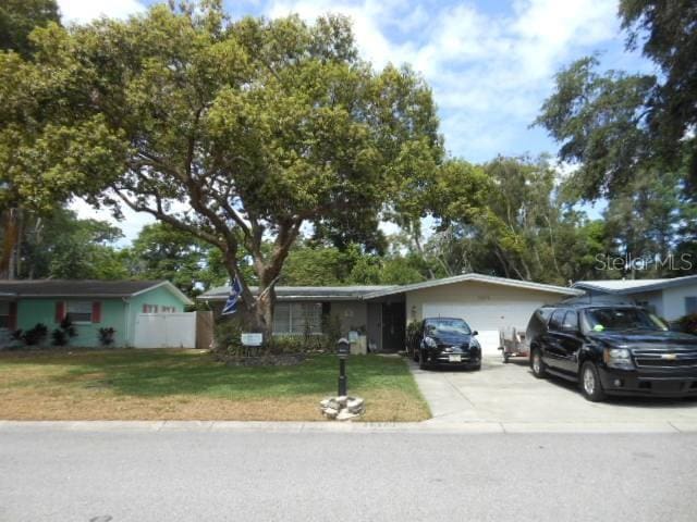 single story home featuring a garage and a front lawn