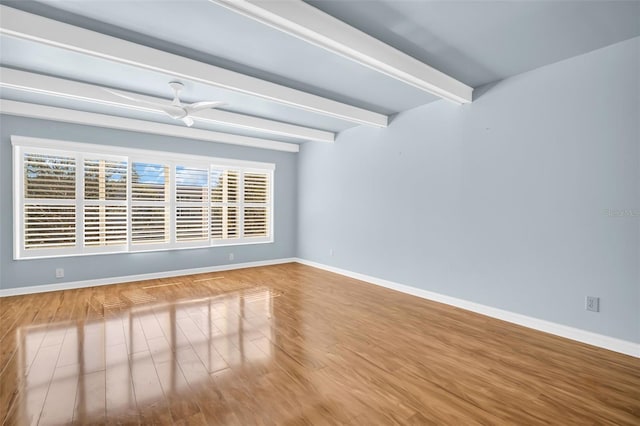 spare room featuring hardwood / wood-style floors, beam ceiling, and ceiling fan