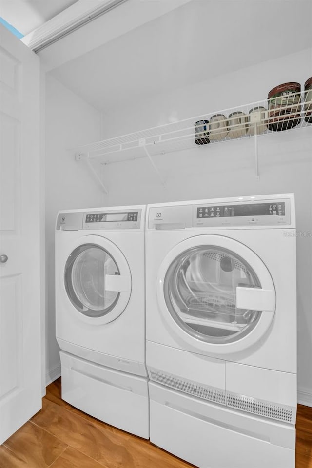 laundry area featuring separate washer and dryer and hardwood / wood-style floors