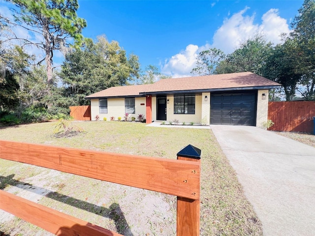 ranch-style house featuring a garage and a front lawn