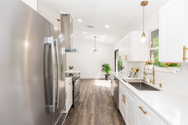 kitchen with appliances with stainless steel finishes, decorative light fixtures, white cabinetry, sink, and backsplash