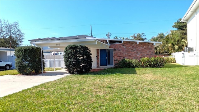 view of front of home featuring central AC, a front lawn, and a carport