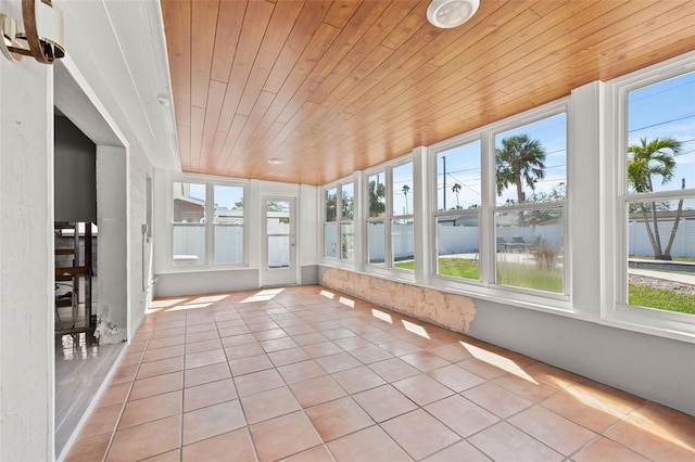 unfurnished sunroom with wooden ceiling and a water view