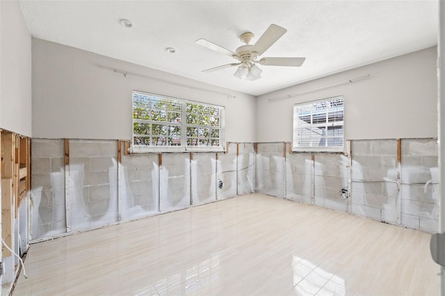 unfurnished room with a wealth of natural light and ceiling fan